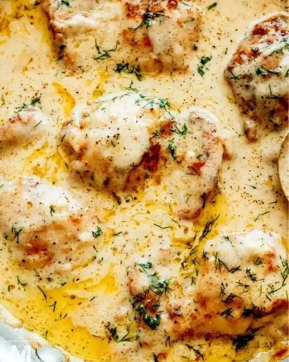 Creamy oven baked chicken thighs served with herbs and sides