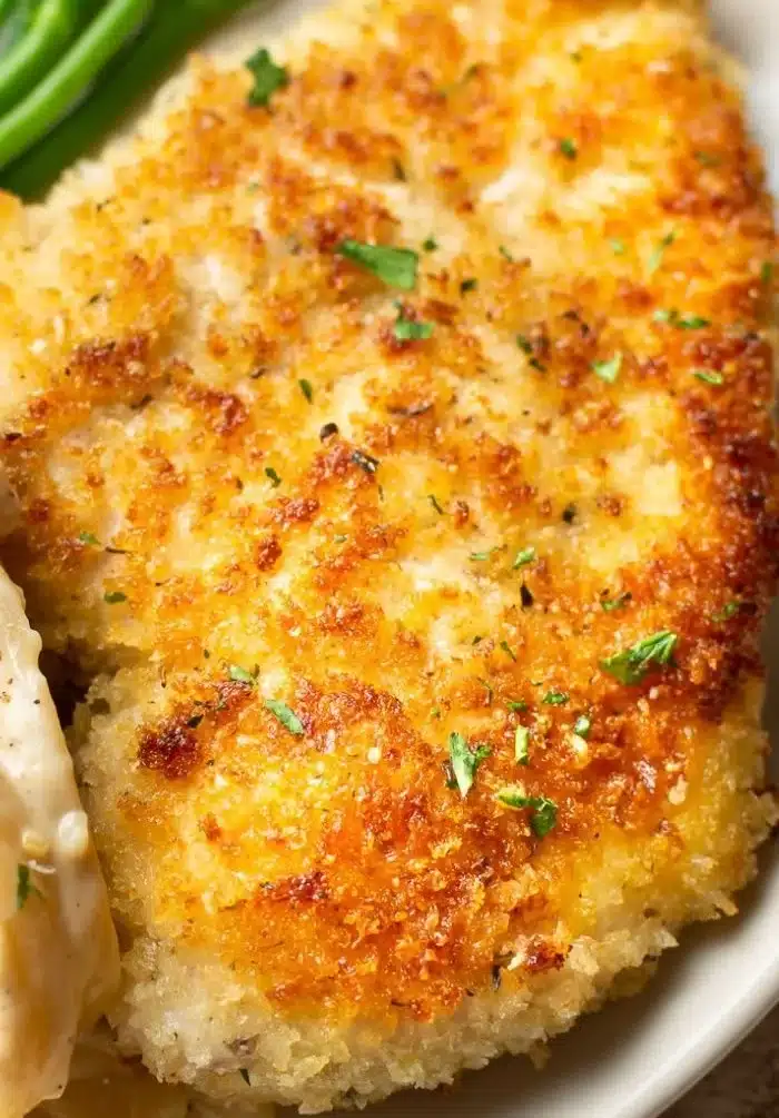 Delicious Parmesan Crusted Chicken served with herbs and spices