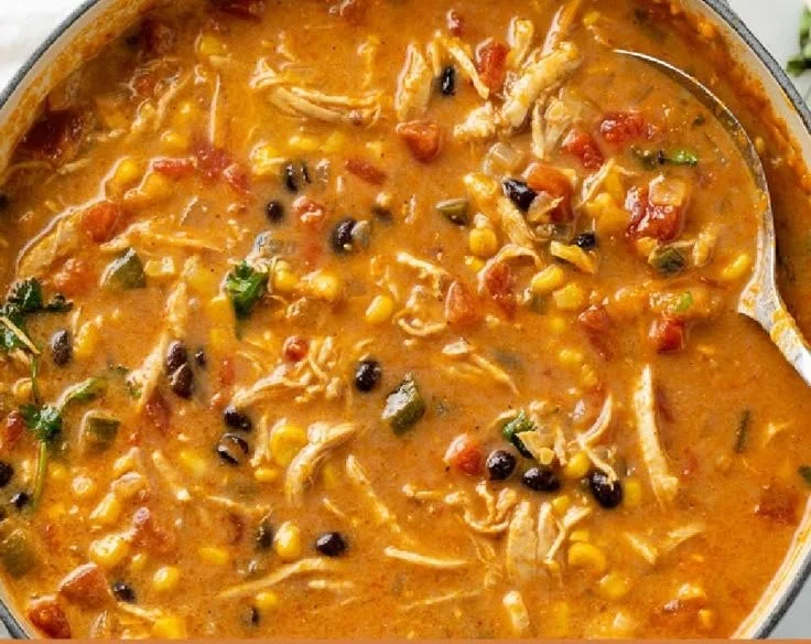 Bowl of creamy Chicken Tortilla Soup topped with tortilla strips and cilantro.