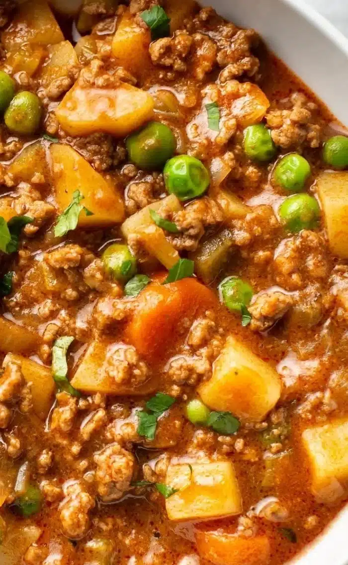 Bowl of easy ground beef stew with vegetables and herbs