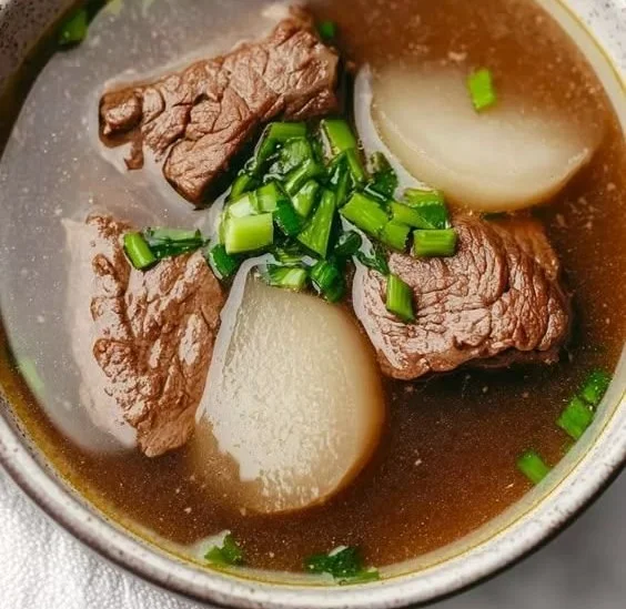 A bowl of steaming Korean winter soup with vegetables and tofu